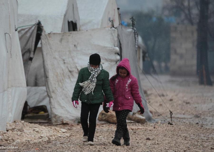 bambina e bambino che camminano in un campo per sfollati in nord est siria