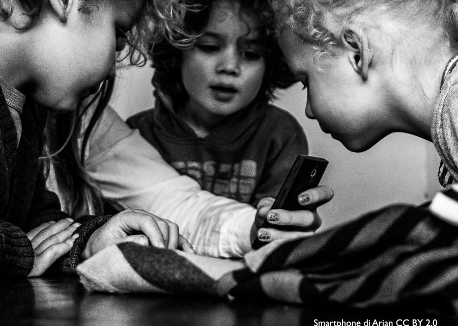 tre bambini guardano lo smartphone