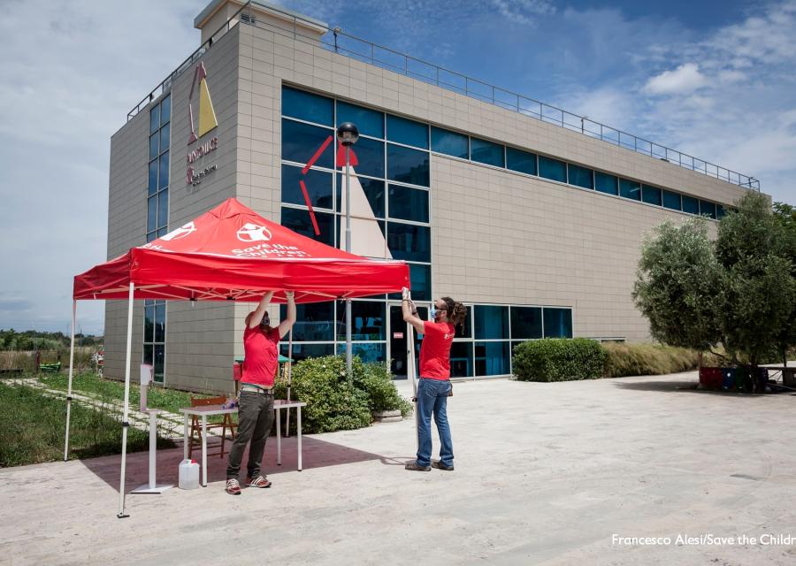 Punto Luce Torre Maura a Roma  gazebo Save the Children allestito da due persone dello staff dell'Organizzazione.