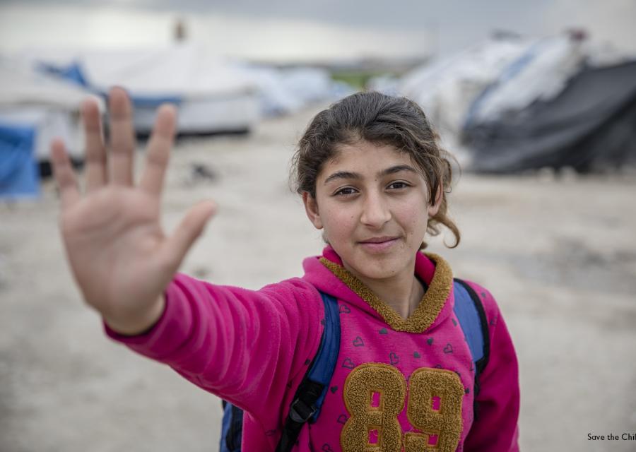 Una bambina siriana fa un gesto a indicare stop con la mano