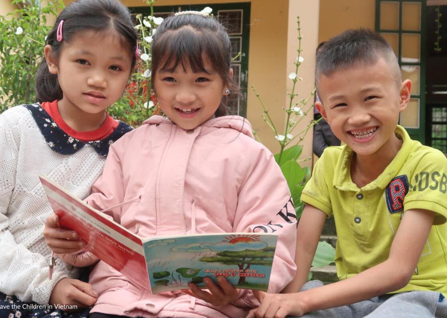 bambine e bambino  che tengono tra le mani un libro