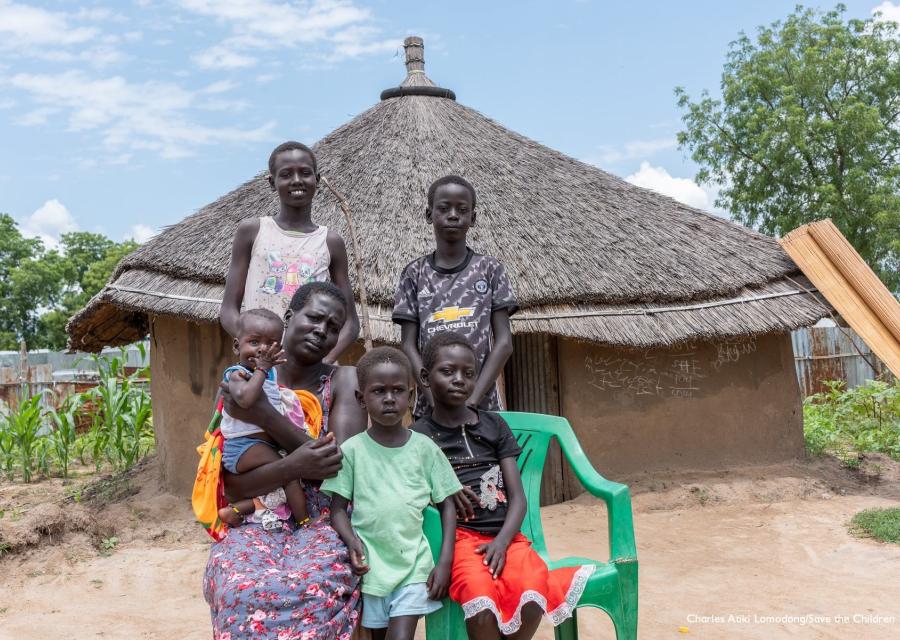 Famiglia sud sudanese in posa davanti alla propria capanna