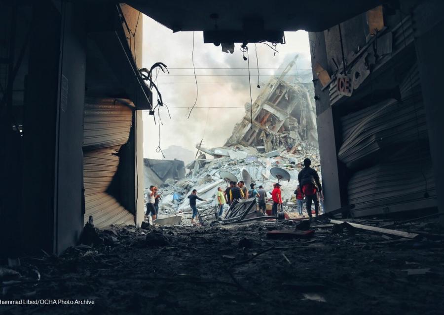 Edificio distrutto nei Territori palestinesi occupati e sullo sfondo persone
