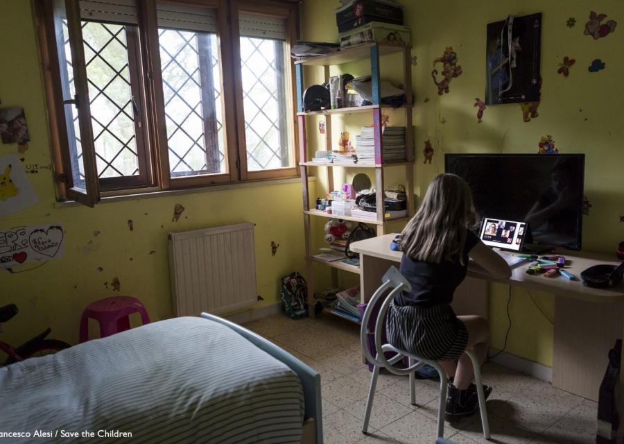 bambina nella sua cameretta da sola che guarda il monitor del tablet