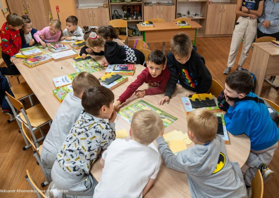 bambini e bambine ucraini con un gioco da tavolo per proteggersi dalle mine