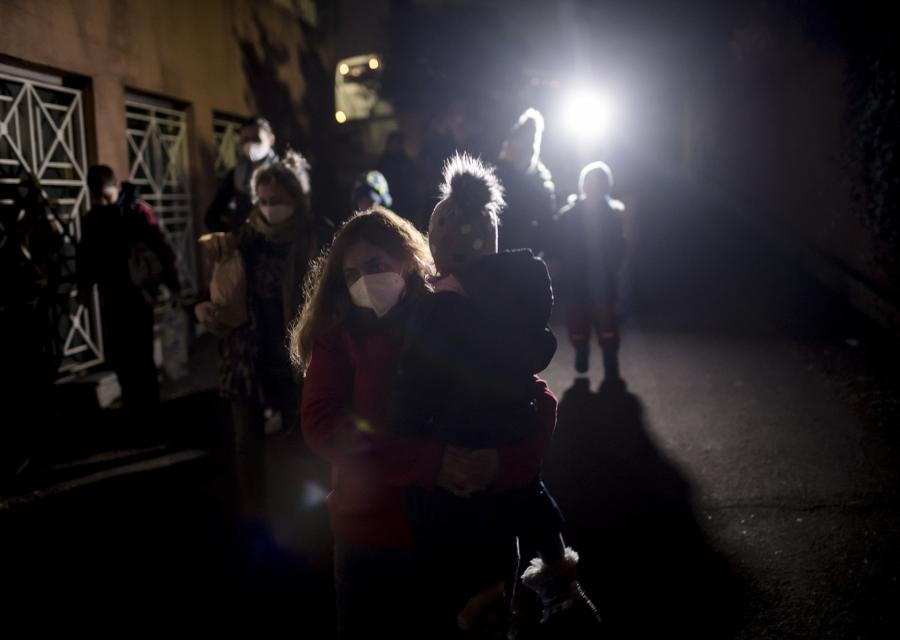 operatrice save the children con in braccio un bambino ucraino durante l'intervento di aiuto in Ucraina