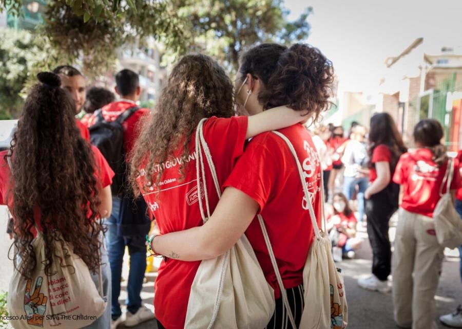 Due ragazze con la maglietta di Save the Children si abbracciano - immagine simbolica per rappresentare la lotta alle discriminazioni e agli stereotipi