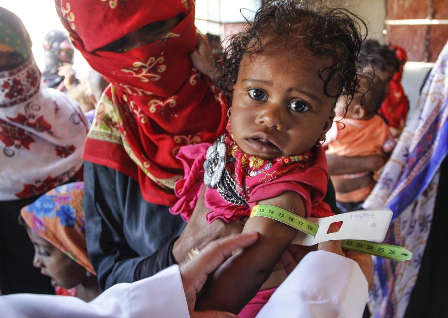 Bambina yemenita in primo piano e mamma dietro di lei coperta dal velo
