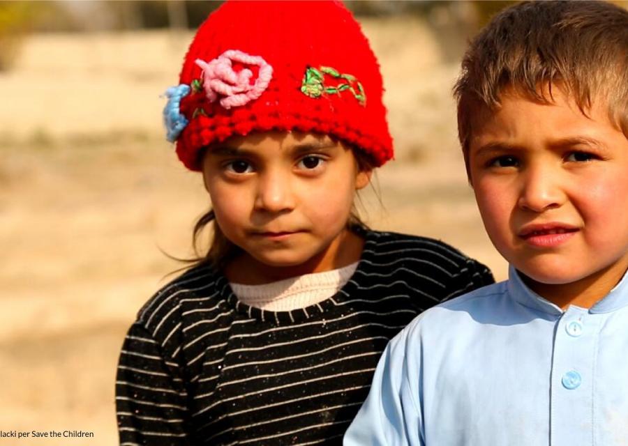 un bimbo e una bimba ci guardano, lei con cappellino rosso e maglioncino nero e bianco a righe e lui con una camicia azzurra. Sono tristi.
