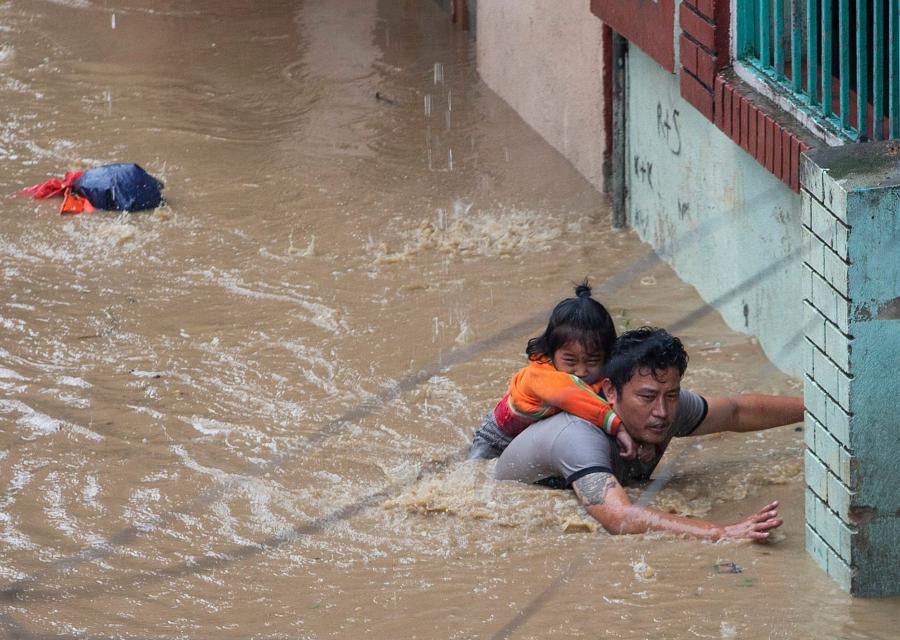 Un padre con la sua bambina che cerca di mettersi in salvo dall acqua alta