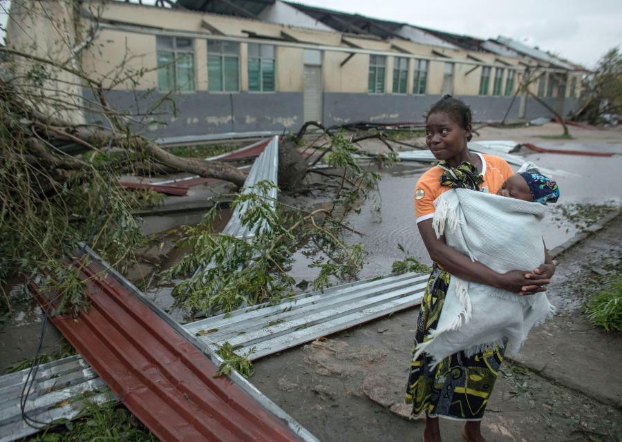 una madre con in braccio il suo piccolo bambino con alle spalle la devastazione provocata dal ciclone Idai che ha distrutto case e allagato intere aree in Mozambico, Malawi e Zimbabwe
