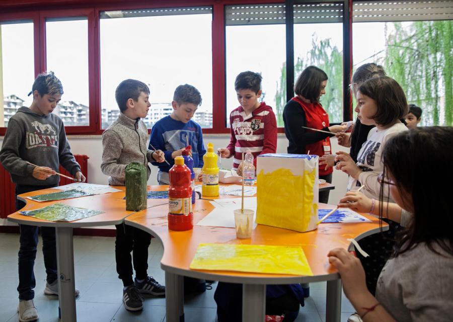 bambini riuniti attorno ad un tavolo mentre svolgono attività 