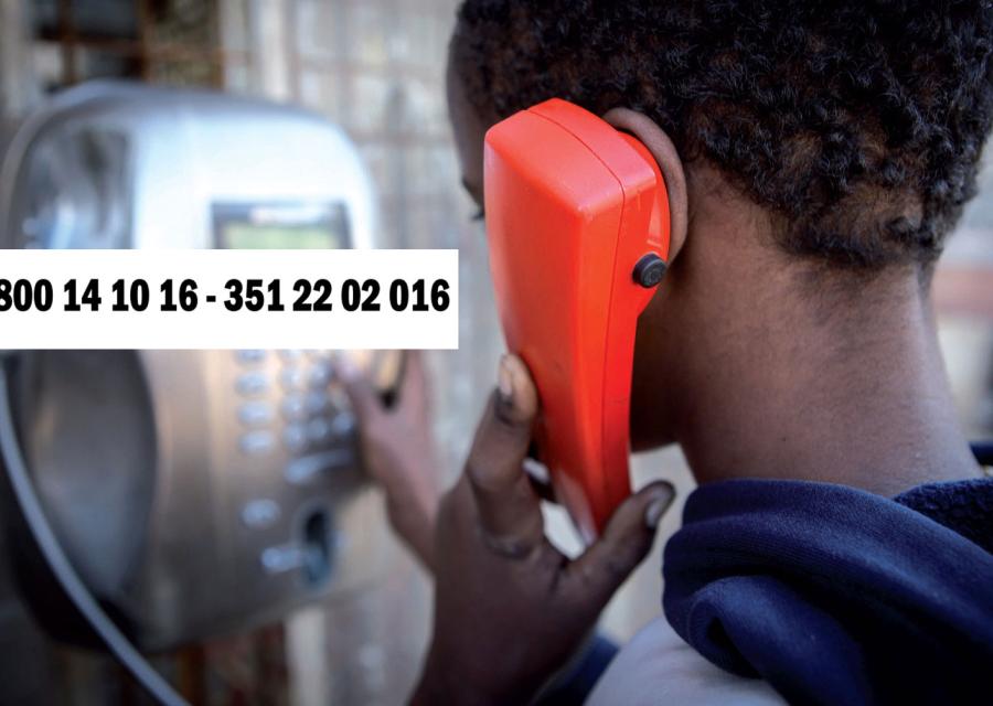 helpline per minori migranti ragazzo che telefona ad una cabina telefonica