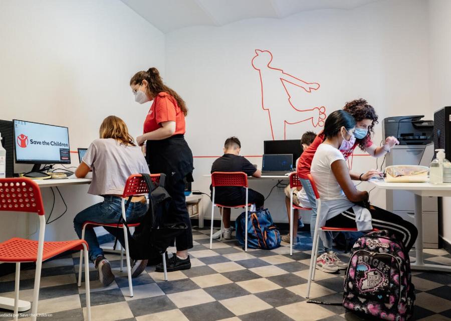 Gruppo di bambini in aula computer con operatore che li assiste 