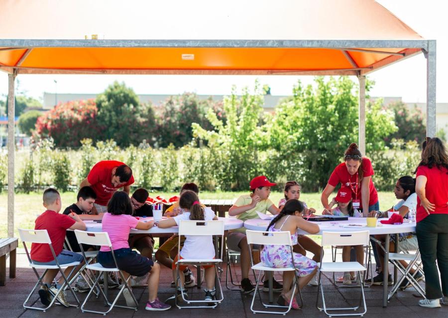 bambini intorno ad un tavolo disegnano
