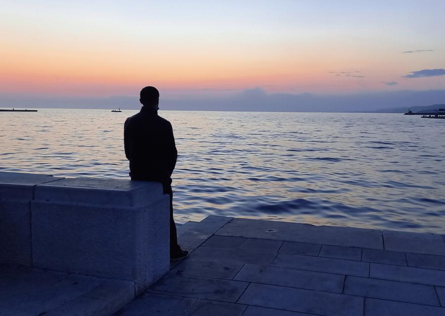 Ragazzo di spalle che guarda il mare
