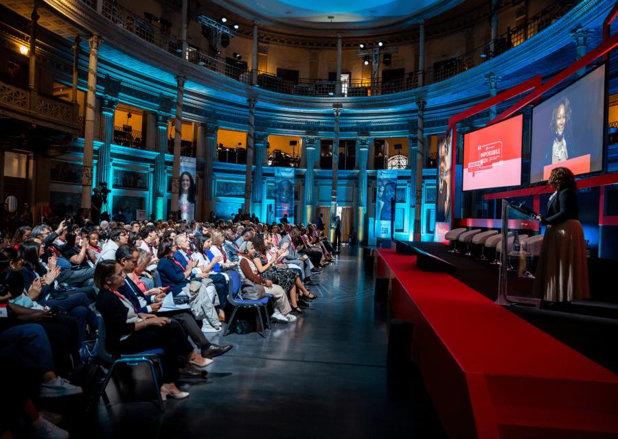 copertina evento Impossibile 2024 Save the Children Italia, ospiti seduti in auditorium con relatrice sul palco