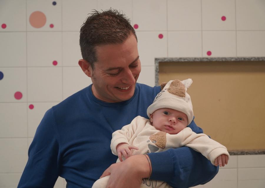 Papà sorridente con in braccio bambino piccolo 
