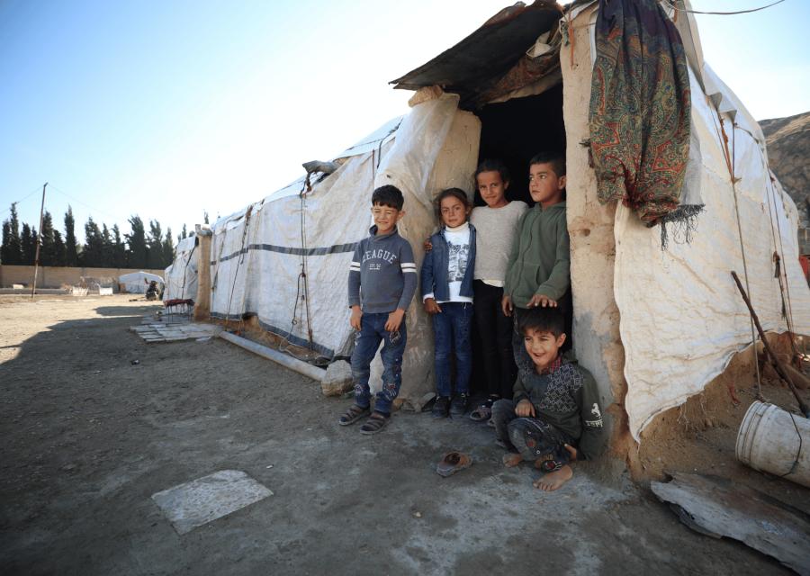 5 bambini di fronte al tendone dove vivono.