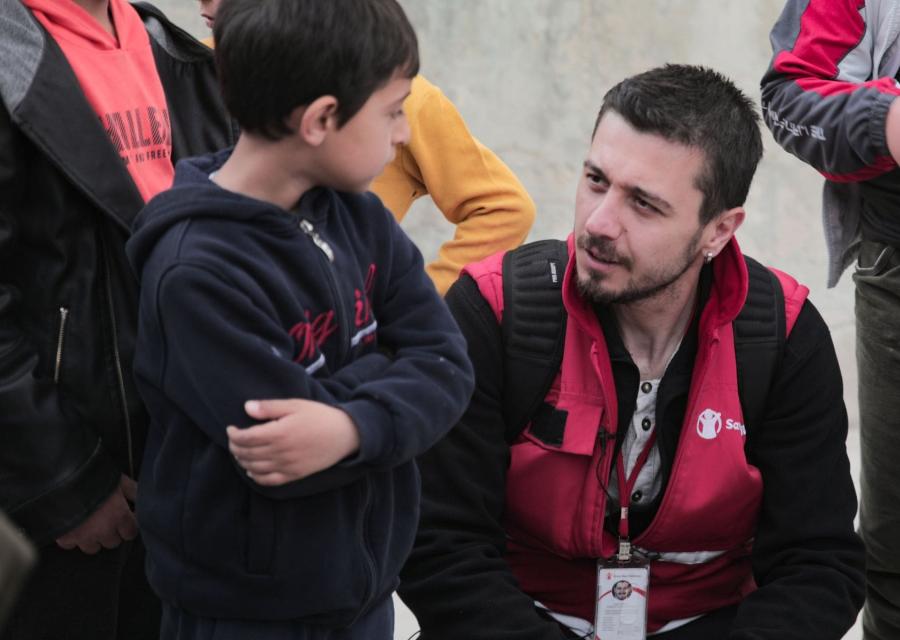 operatore Save the Children accanto a bambino che parlano