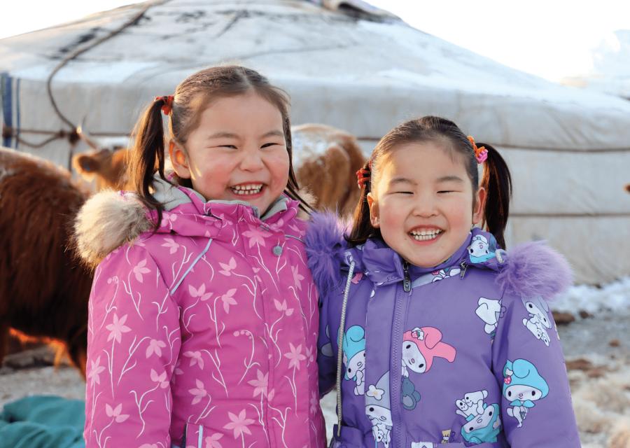 Coppia di bambine sorridenti con giubbini colorari