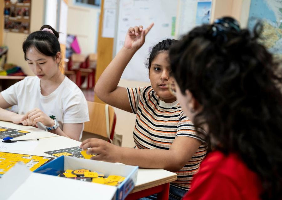 ragazza alza la mano in classe