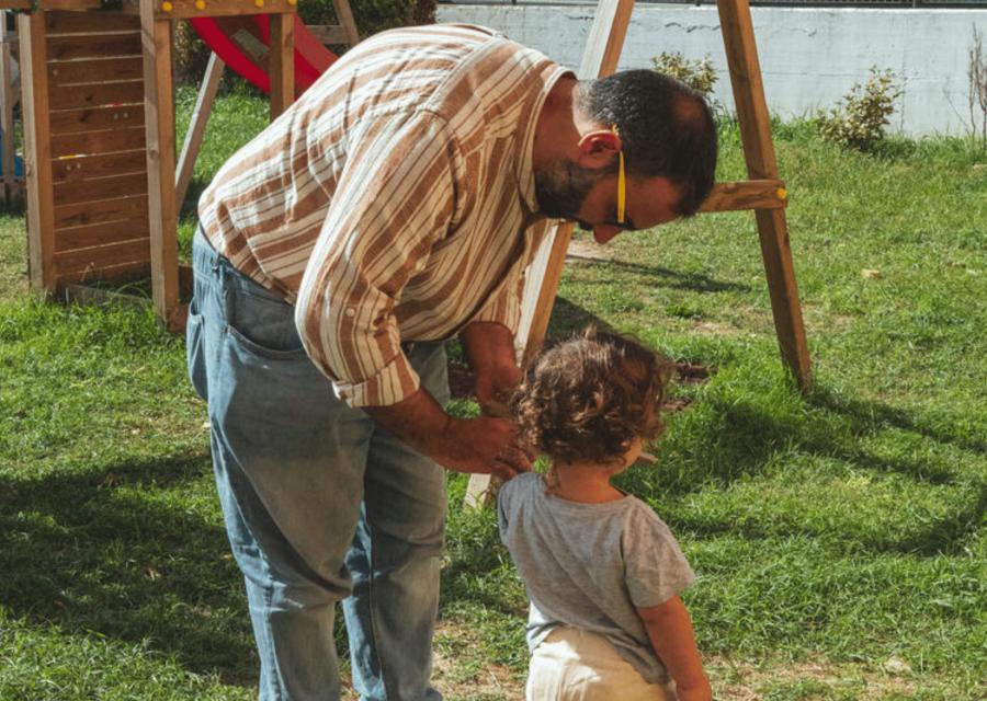 Padre chinato verso figlio in un giardino 