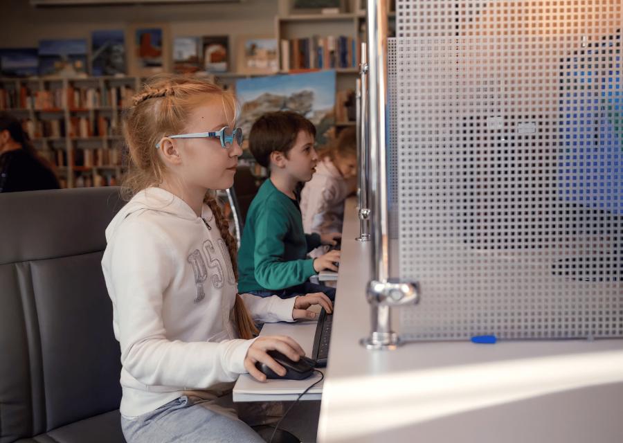Una bambina di profilo che guarda il computer