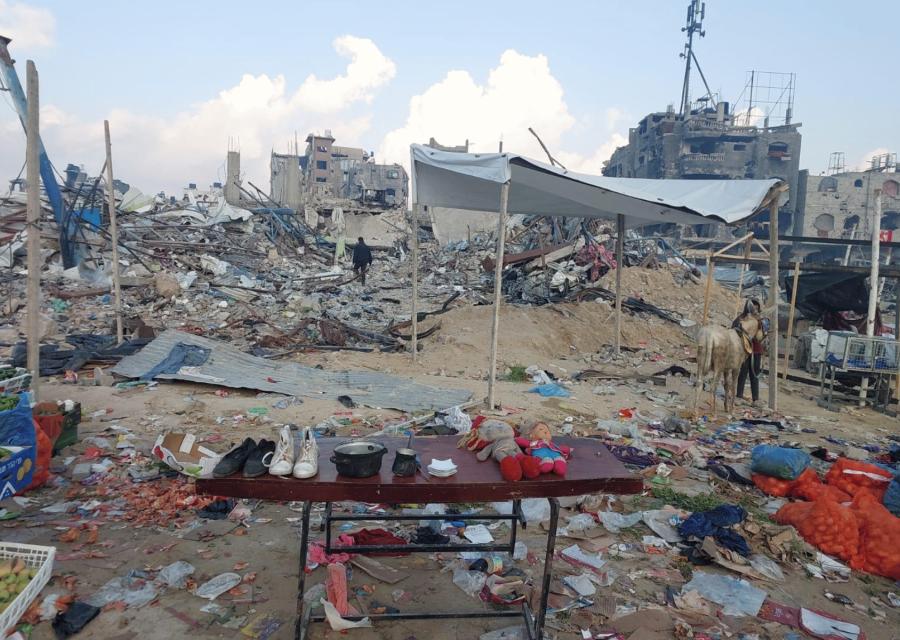 Banco con sopra due bambole su macerie a Gaza