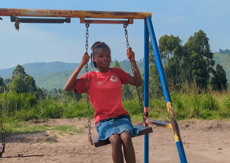 Bambina gioca sull'altalena in uno spazio a misura di bambino nella Repubblica Democratica del Congo