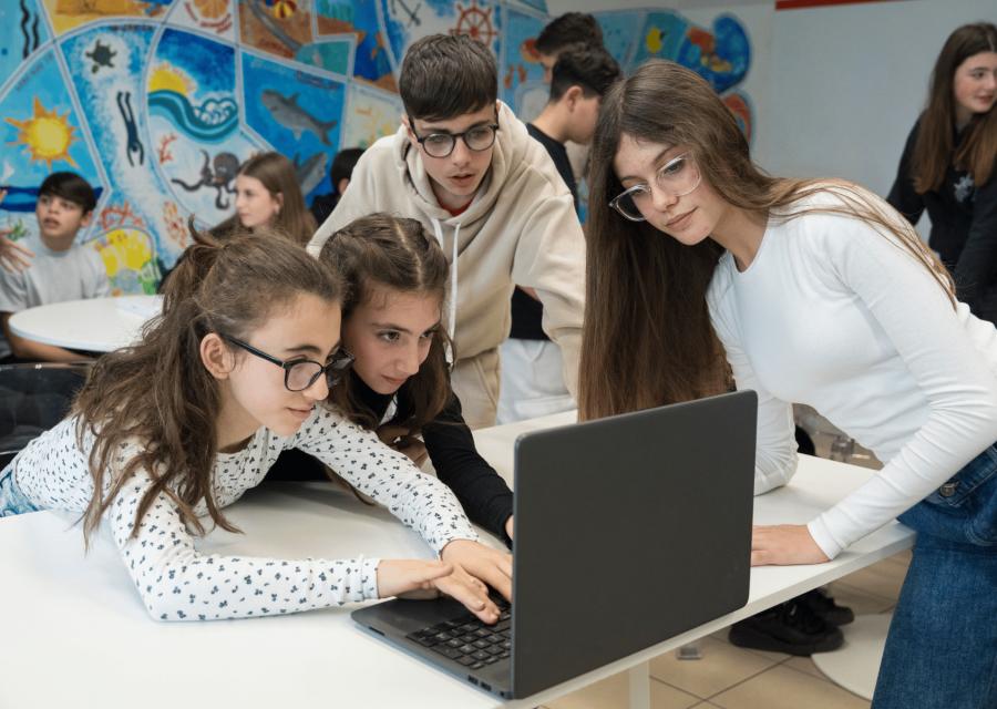 Ragazze e ragazzo di fronte ad un computer in classe