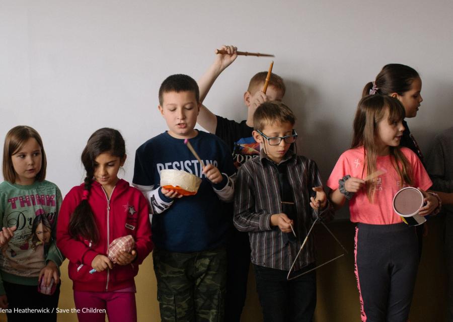 bambini e bambine che fanno musica a scuola con strumenti musicali in mano 