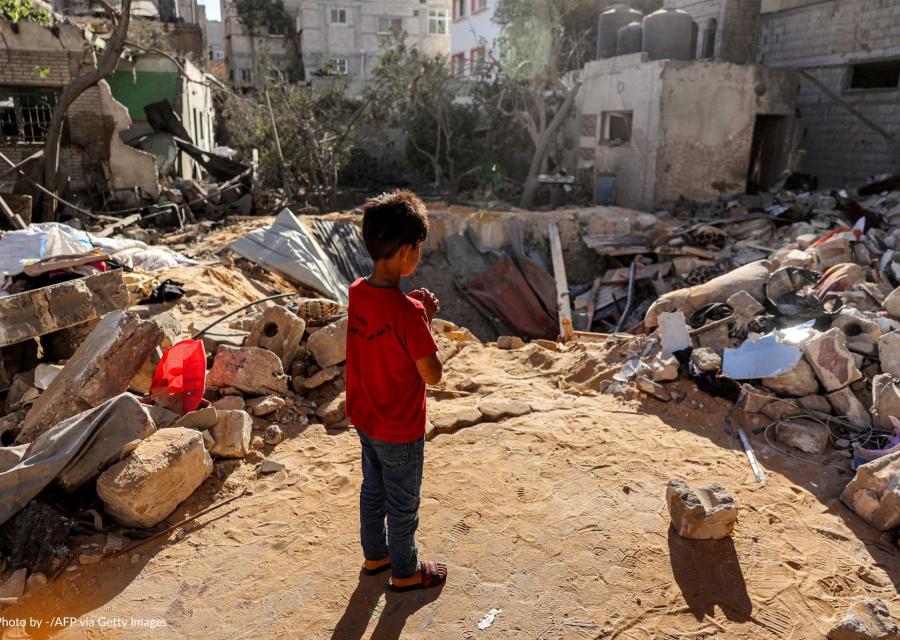 Un bambino di fronte a delle macerie a Gaza