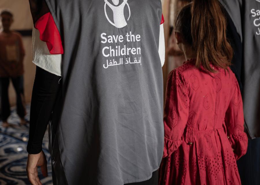 Save the Children staff tiene la mano a una bambina a Gaza