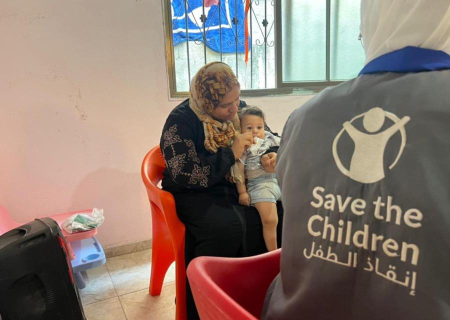 Madre con bambino malnutrito di fronte ad operatore Save the Children a Gaza