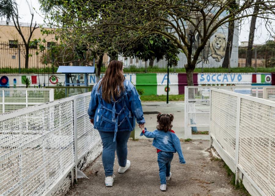 mamma con bambina che camminano mano nella mano di spalle