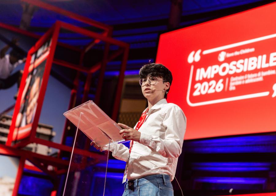 Ragazza che parla con microfono su palco evento Impossibile 2026