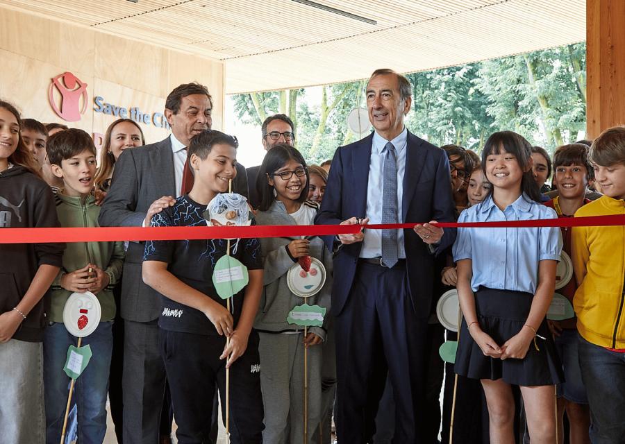 Taglio del nastro rosso per l'inaugurazione con il sindaco di Milano, Giuseppe Sala, al centro e bambini e bambine intorno.