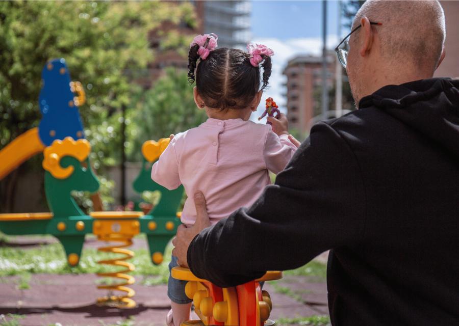 bambina  con maglietta rosa in braccio a papà