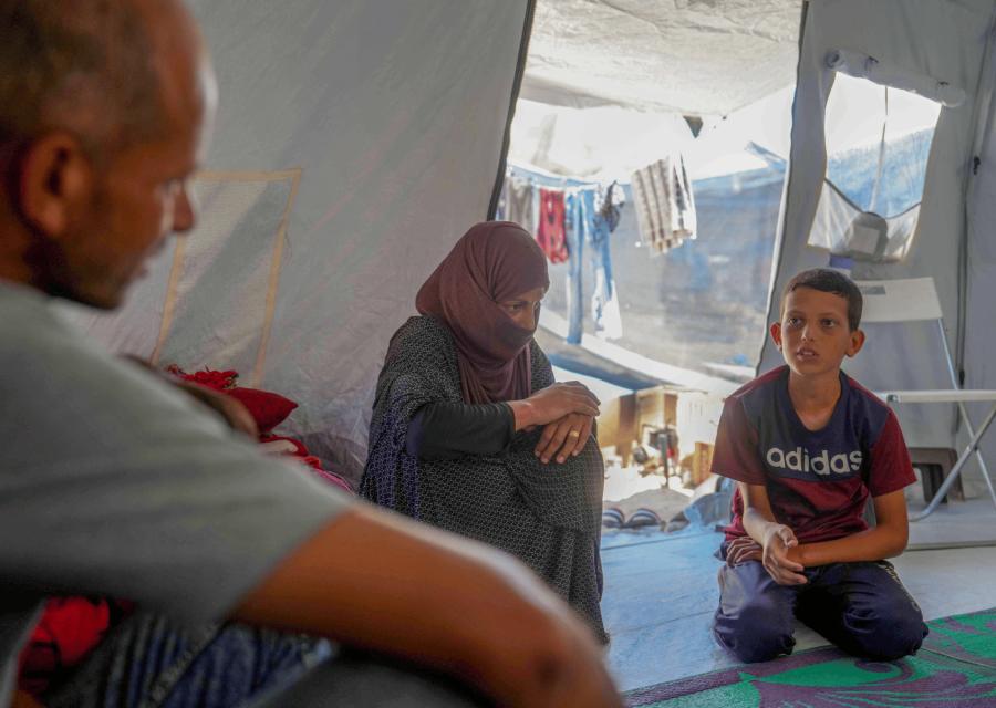 Bambino con genitori nella loro tenda a Gaza