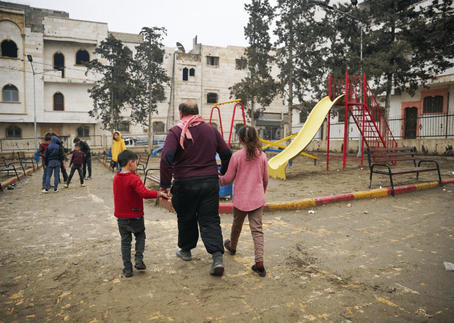 Bambini in un parco giochi accompagnati dal padre