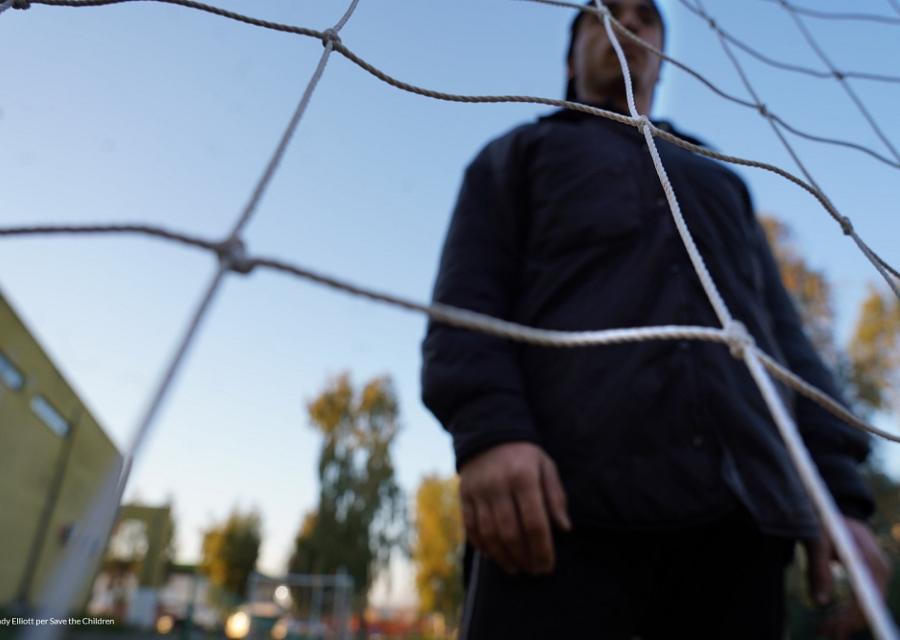 ragazzo sullo sfondo di fronte ad una rete di calcio 