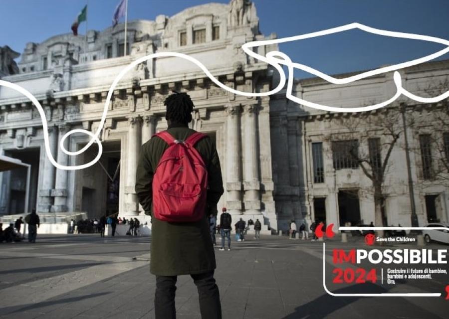 ragazzo di spalle con zaino rosso di fronte a un monumento 