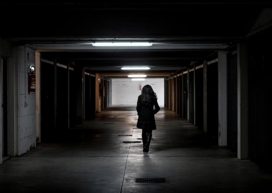 Donna che cammina in un corridoio buio