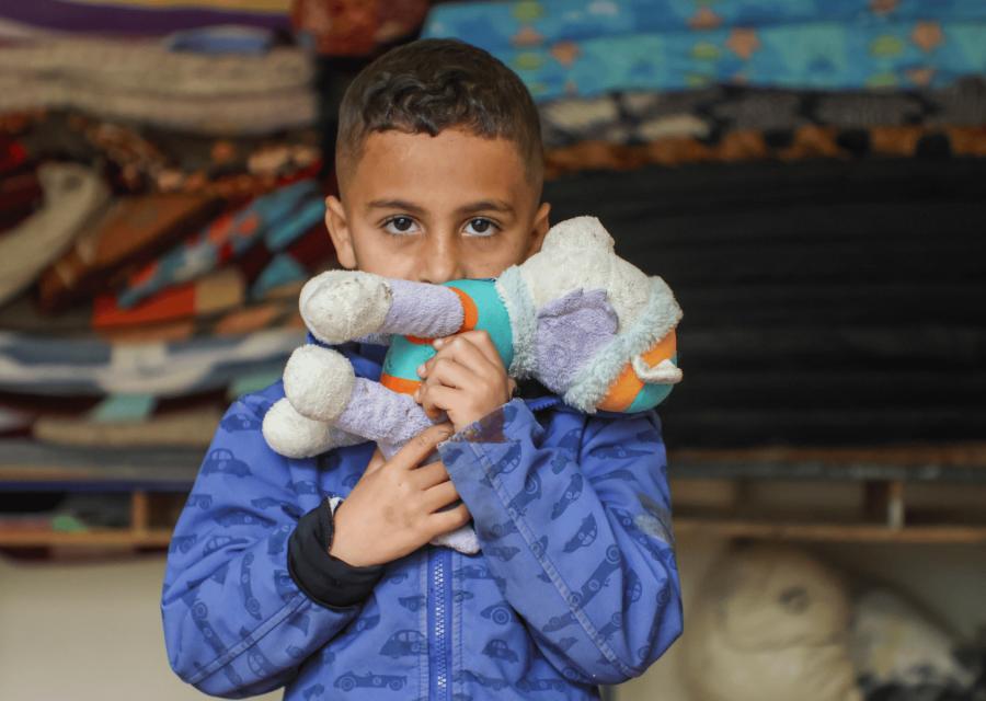 bambino che tiene davanti alla bocca un peluche 