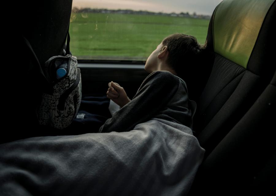 bambino che sta appoggiato al finestrino di un autobus 