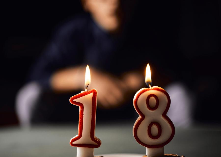 Candeline di 18 anni e sullo sfondo ragazzo 