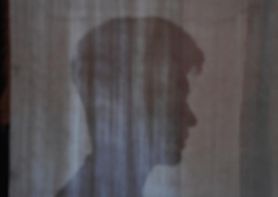 Profilo in ombra di bambino Rohingya dietro una tenda