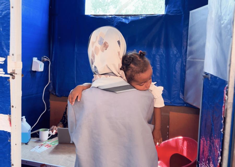 Madre di spalle con in braccio bambino 