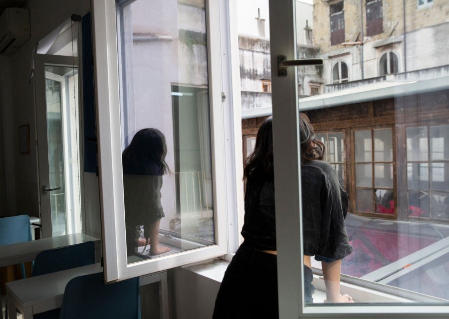 ragazza che guarda fuori da una finestra 